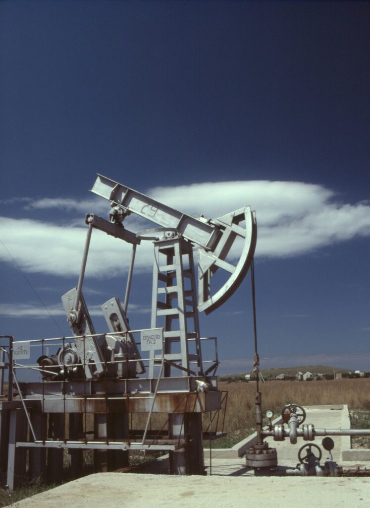 Oil pumpjack in operation against clear blue sky, highlighting industrial energy production.